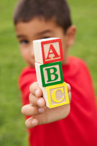 Boy holding blocks with A, B, C on the blocks